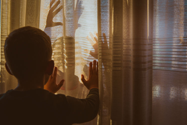 Rear view of woman looking through window