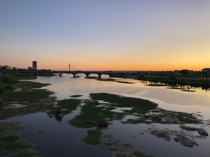 Scenic view of river against clear sky during sunset