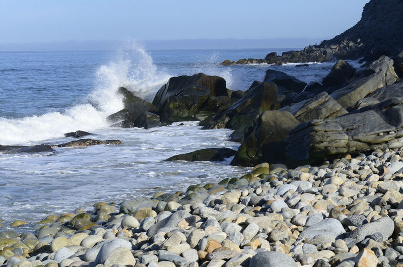Pacific ocean wave splashes against rocky shore of baja california sur in mexico