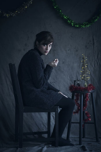 Woman sitting on chair with christmas decorations