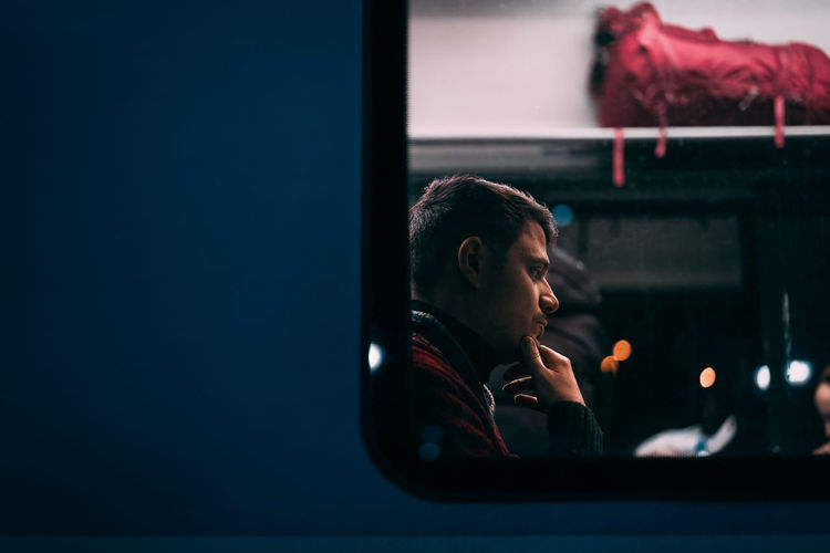 Thoughtful man seen through train window