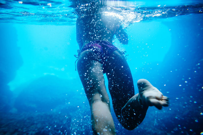 Low section of woman swimming in sea
