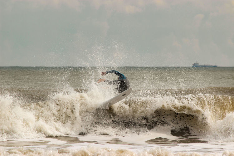 Man surfboarding in sea against sky