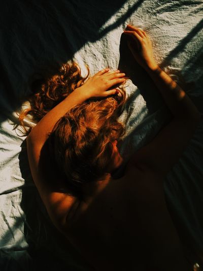 High angle view of woman lying on bed