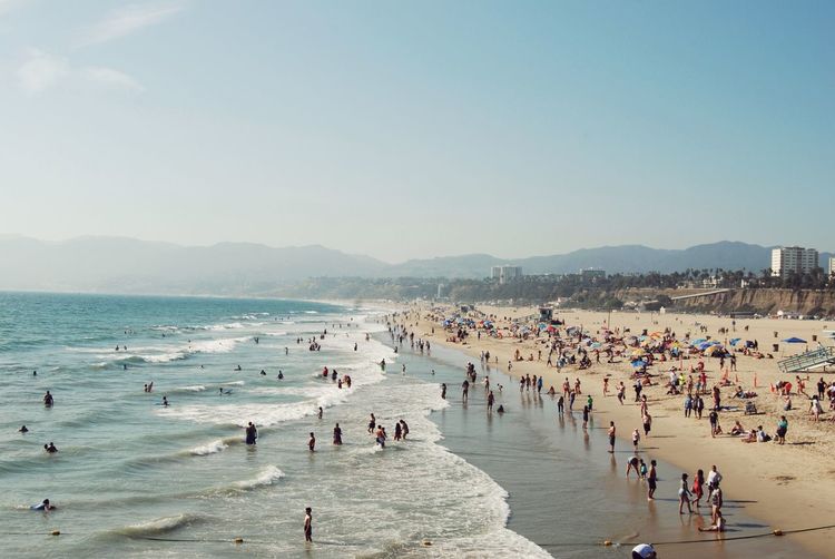 People at beach against sky