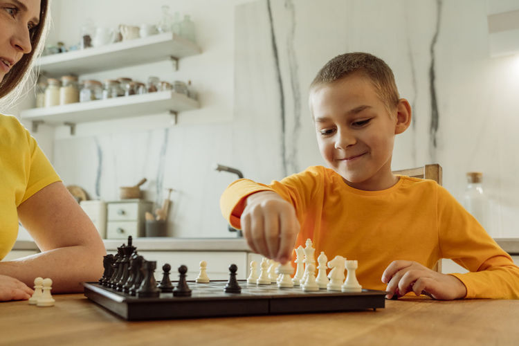 Portrait of boy playing chess at home