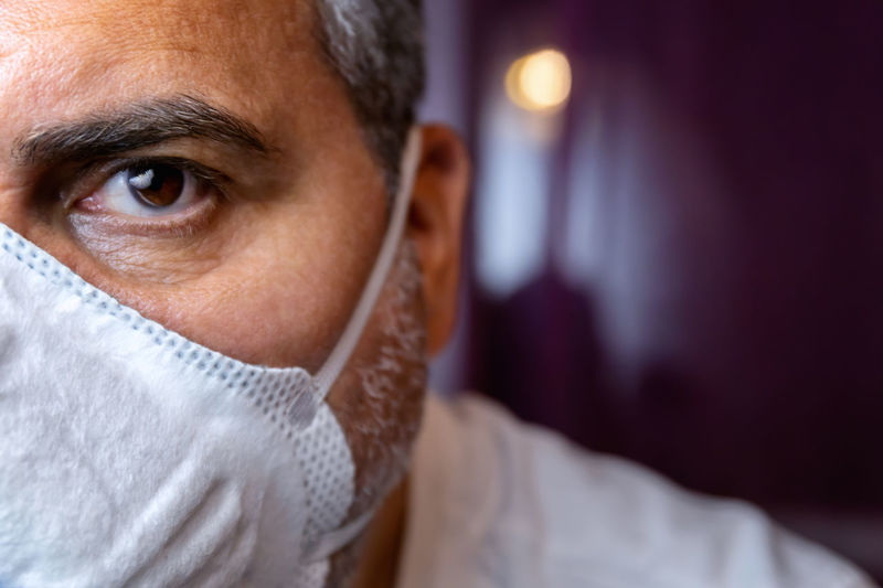 Closeup of man with a protective medical mask waits for the end of the emergency quarantine.