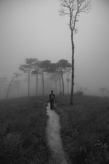 Man walking on field during foggy weather