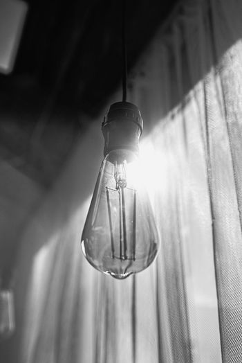 Low angle view of light bulb hanging on ceiling