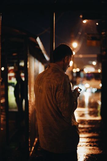 Side view of man using mobile phone at night