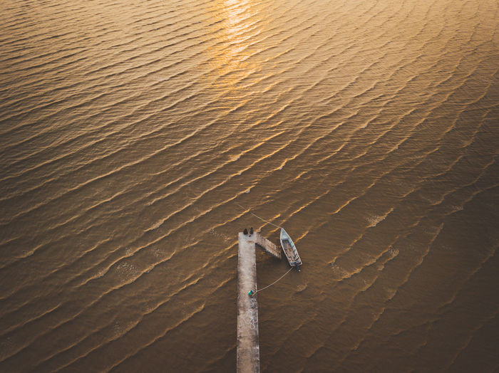 High angle view of fishing boat moored at sea during sunset