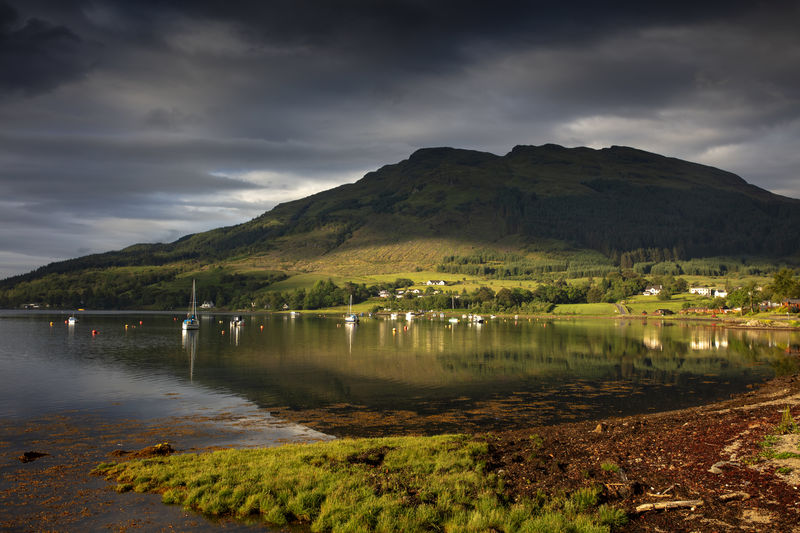 Scenic view of lake by mountains against sky