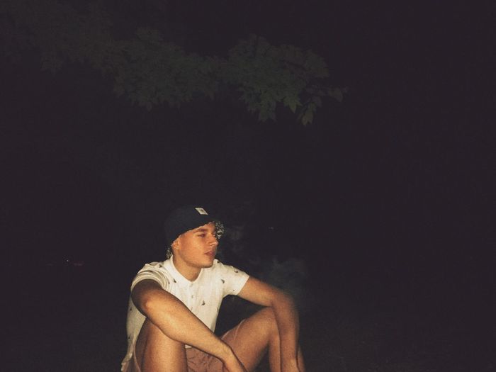 Man sitting outdoors at night