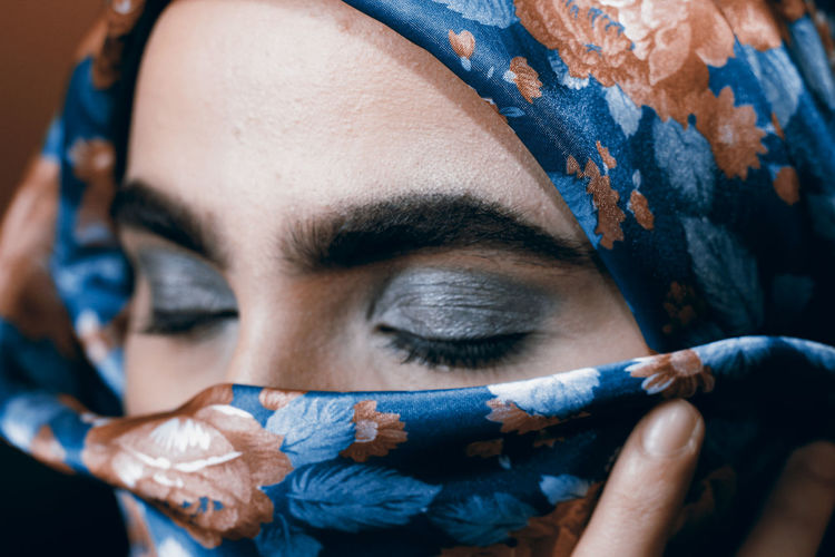 Close-up of woman with gray eye shadow wearing headscarf