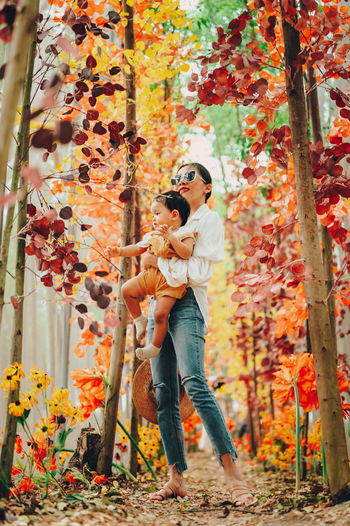 Young couple standing by plants during autumn
