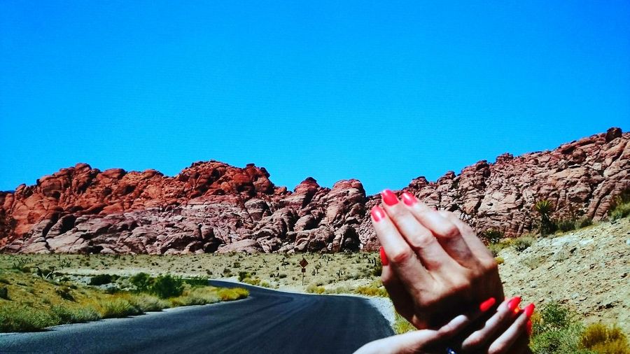 Cropped hands of woman against rock formations at red rock canyon national conservation area