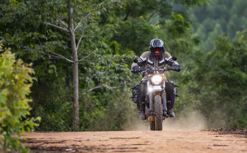 Man riding his motorbike on gravel road in pak chong / thailand