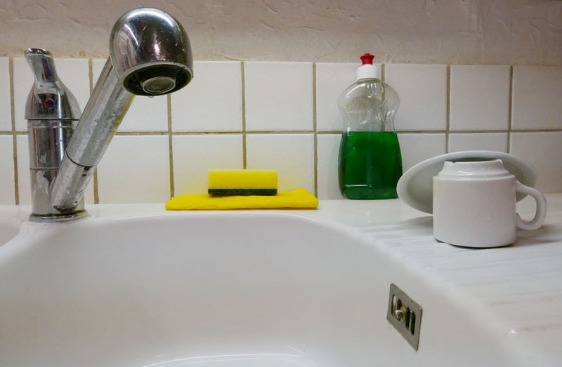 Cleaning equipment and coffee cup on sink