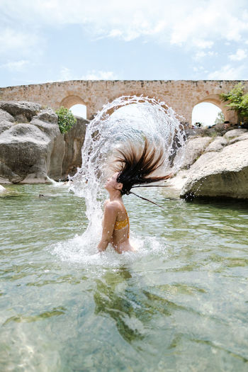 Rear view of woman swimming in water