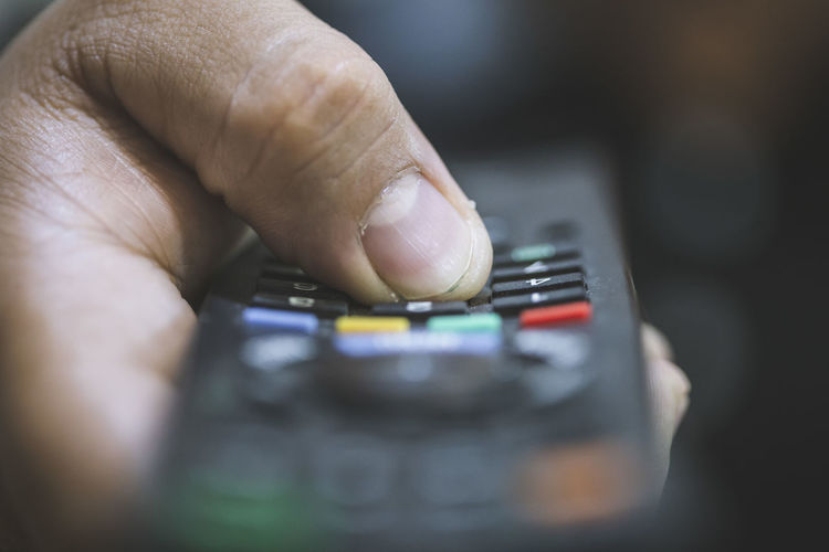 Close-up of person holding remote control