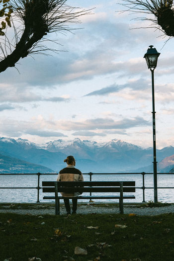 Gazing at alps from belagio, man sitting on a bench, mountain landscape