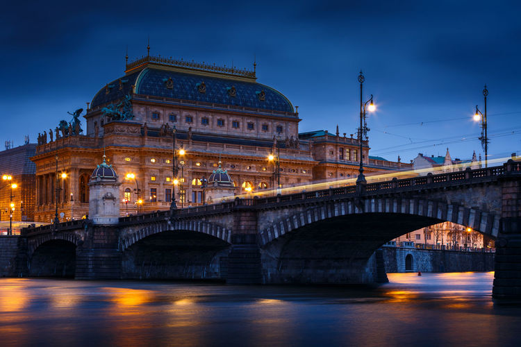 Evening view of the legions bridge and national theatre in prague.