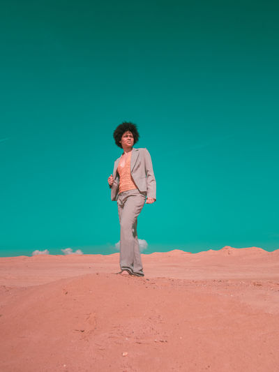 Full length of young man standing on sand