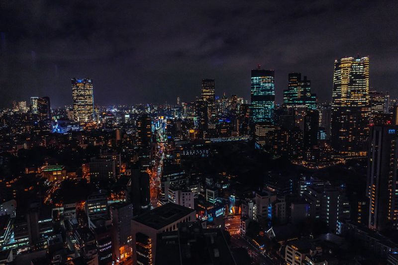 Illuminated cityscape against sky at night