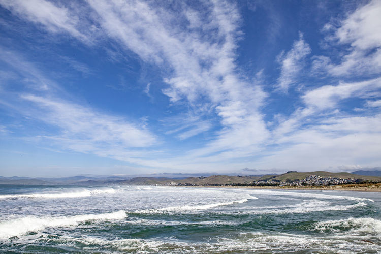 Scenic view of pacific ocean against blue skies in morro bay, california.