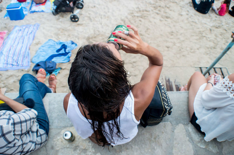Woman drinking beer at the beach