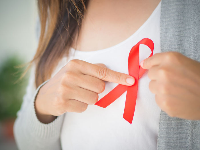 Midsection of woman with aids awareness ribbon