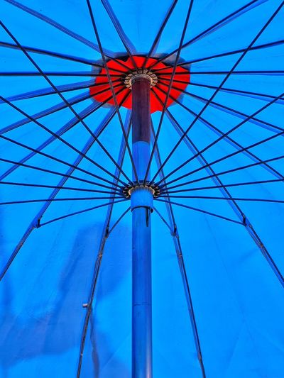 Low angle view of ferris wheel against blue sky