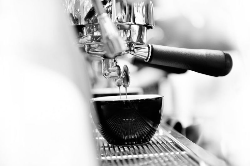 Close-up of coffee pouring from faucet