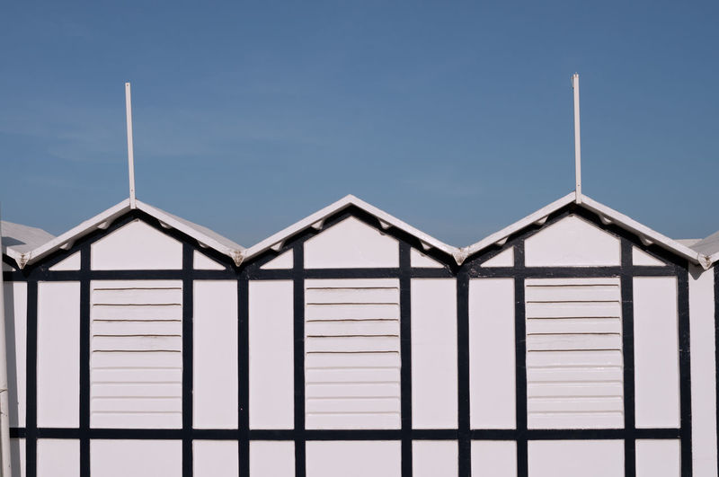 Detail of typical beach huts in italy. white, with a beautiful blue sky in the background