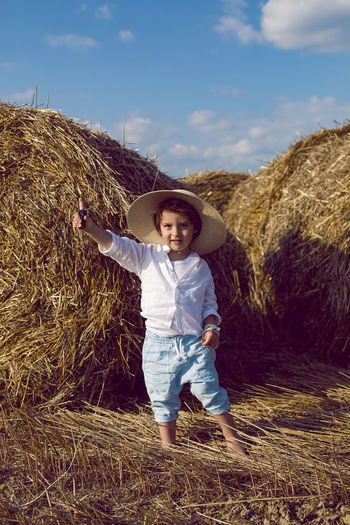 Portrait of boy standing on hay