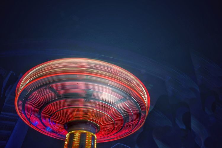 Blurred motion of amusement park ride at night