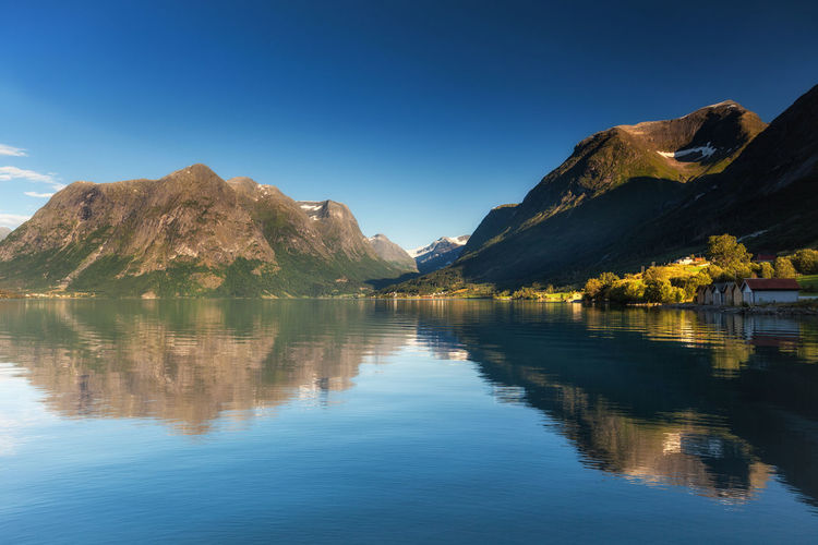 Scenic view of lake and mountains against blue sky. oppstrynsvatnet lake, stryn, norway