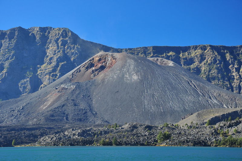 Panoramic view of volcanic mountain against clear blue sky