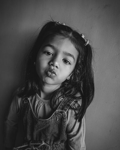 Portrait of smiling girl against wall