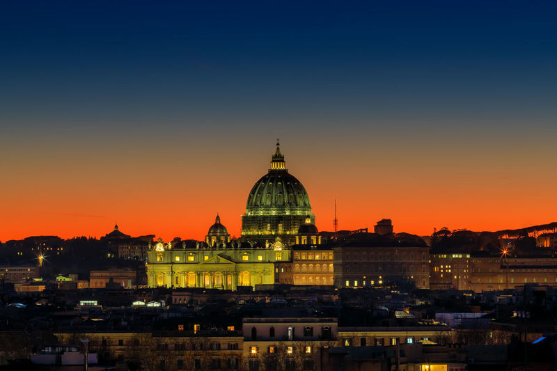 Sunset on the skyline of rome city, with the dome of st. peter's cathedral in the center.