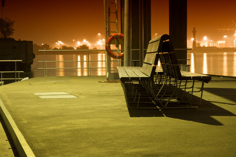 Life belt on structure by benches at harbor against elbe river
