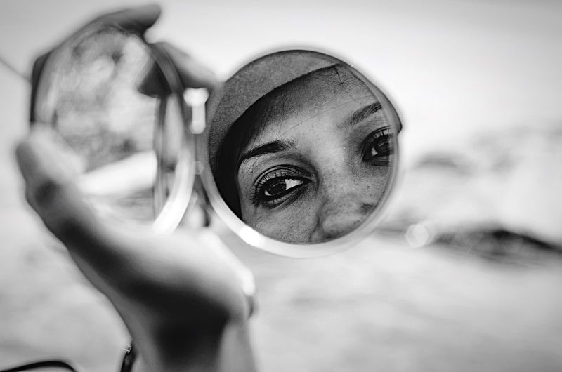 Reflection of woman face on hand mirror