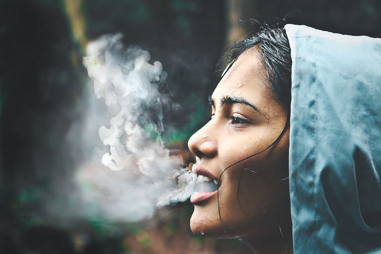 Portrait of woman smoking outdoors