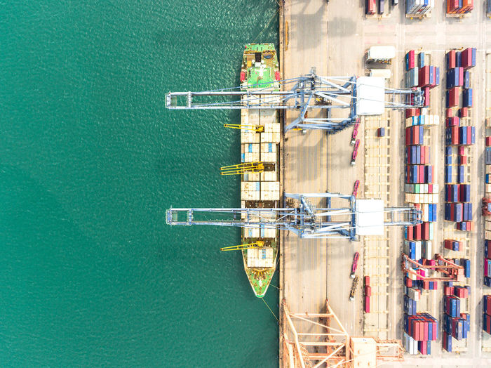High angle view of cargo container with crane by sea