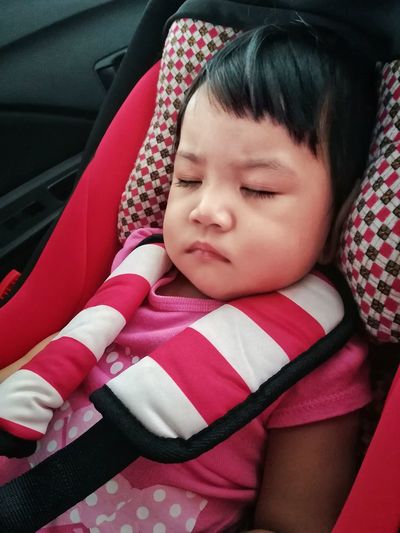 High angle view of baby girl sleeping on car seat
