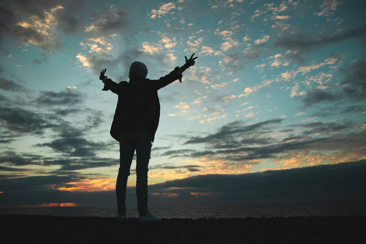 Low angle view of silhouette man standing against sky during sunset
