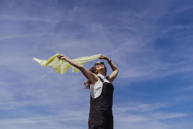Low angle view of woman standing against the sky