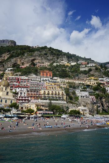 Scenic view of town by sea against sky