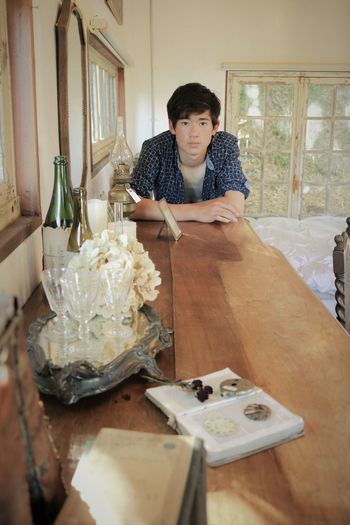 Portrait of teenage boy by table at home