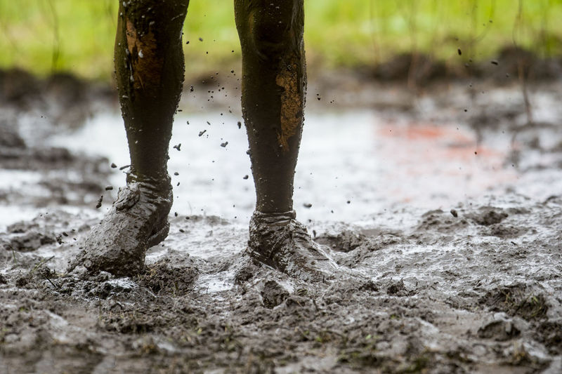 Low section of man running in mud